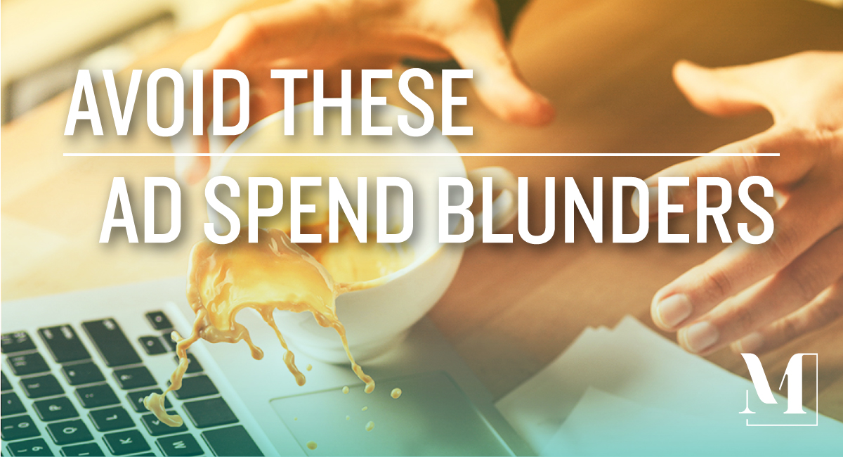 An individual trying to catch a cup of coffee before it spills on an open laptop. Text: avoid these ad spend blunders.