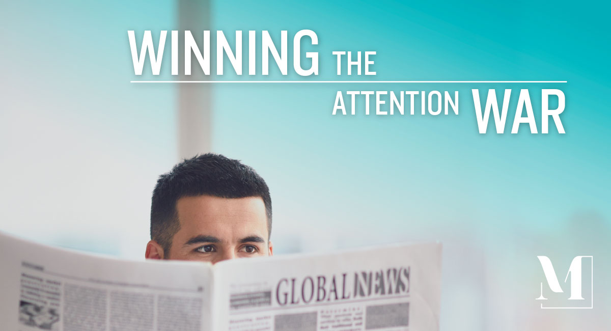 Man reading the newspaper with text: "Winning the attention war."