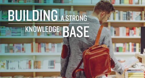 A young man in a library, picking up a book from the table with text: "Building a Strong Knowledge Base"